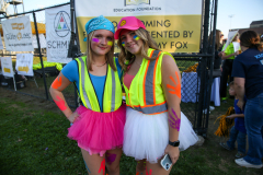 Two people in colorful costumes standing next to each other at an event.