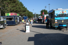 Food trucks parked in a parking lot during an event.