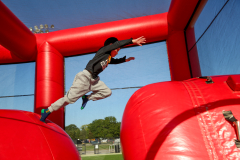 Boy in black shirt on inflatable bounce house at carnival.