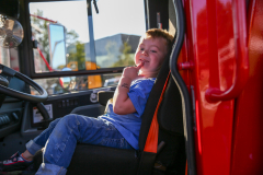 Young boy sitting in a red fire truck.