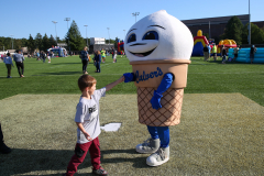 Man in blue shirt pointing at ice cream cone mascot.