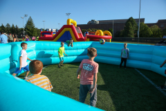 Children playing in inflatable pools at a carnival.