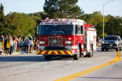 Fire truck driving down a street during a parade.