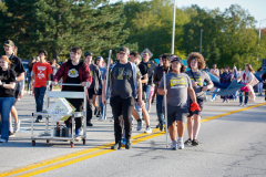 People walking down a street in a parade.