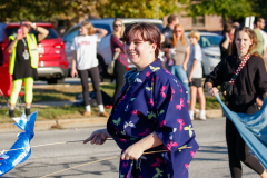 Woman in a kimono holding a blue kite at a parade.