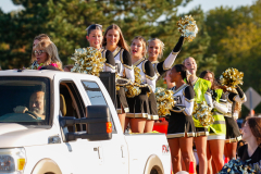 Cheerleaders celebrating on a float during a parade.