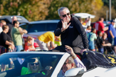 Man in a car waving at people.