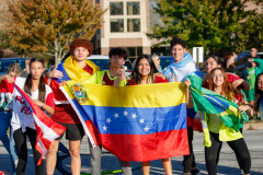 People holding flags of different countries, celebrating diversity at a parade.