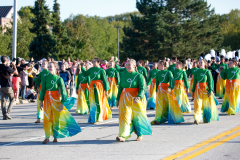 Group of people in colorful costumes performing at a parade.