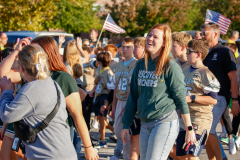 Woman wearing a green hoodie walking in parade.
