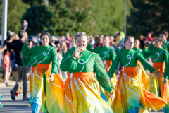 People in colorful costumes dancing in a parade.