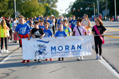 Group of people holding a banner on a roadway during a parade.