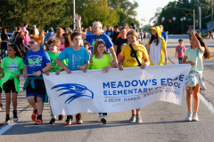 Group of people holding a banner at an event, smiling and posing for the camera.