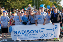 People in a group holding a banner that says madison elementary school, posing for a picture at an event.