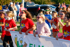 Children in red shirts running a race.