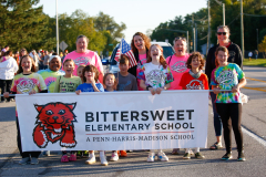 Children posing in front of a banner for the Bitter Sweet Elementary School float at the HOCO Parade.