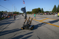 People gathered at a parade, watching floats go by on a sunny day.