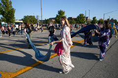 People in costumes performing at a parade.