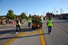 Parade participants walking in a group on a street.