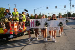 Cheerleaders celebrating hoco parade with sign reading '241004 HOCO Parade Floats'".