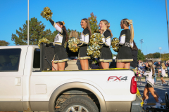 Several cheerleaders celebrating on a float at a parade.