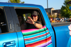 Man in a truck waving at the camera.