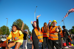 People in orange vests celebrating at a parade.
