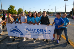 Group of people holding a sign at a parade.