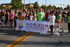 Children walking in a parade holding a sign that says "Horizon Elementary School".