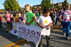 People walking in a parade holding banners.