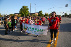 People standing on a street holding signs, participating in a parade.