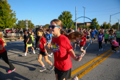 Girl in red shirt running in hoco parade.