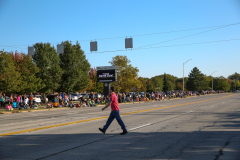 Spectators at a parade on a street corner.
