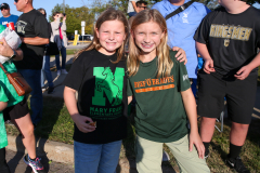 Two girls posing together at a sporting event.