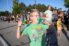 Young boy drinking soda at a parade.
