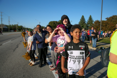 People gathered on a street at a parade event.