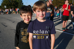 Two young boys posing together at a parade event.