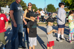 People gathered on a street for a parade, watching floats pass by.