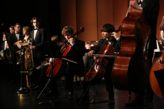 An orchestra performing on stage with a conductor.