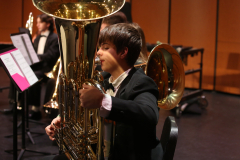 Person playing a large tuba in an orchestra.