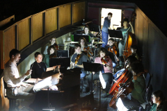 A symphony orchestra performing in a small room.