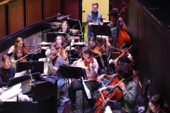 Musicians performing on stage in front of an audience.