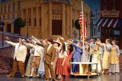 Theatrical stage production of "Music Man" in 2024, featuring a large cast on stage.
