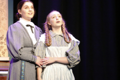 Two women on stage in a musical theater production.