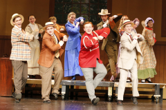 Musical theater cast on stage performing in a production of The Music Man.