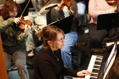 Woman playing piano in an orchestra.