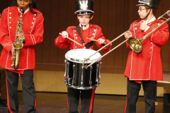 Three musicians playing instruments on stage.