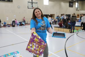 Teacher holding artwork done by Sphero bot