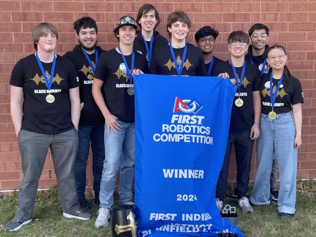 Robotics team with medals and a "Winner" banner from FIRST Robotics Competition.