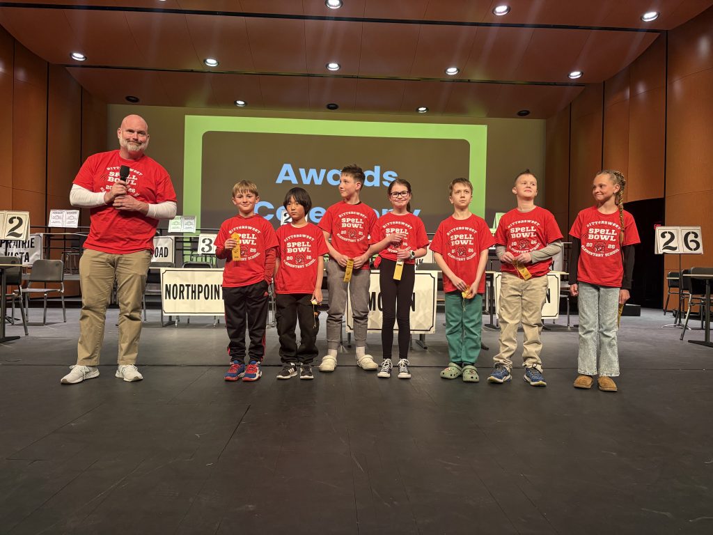 People posing on stage at an awards ceremony.